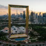 Aerial view of Dubai Frame with cityscape backdrop at sunset. Iconic landmark in UAE.
